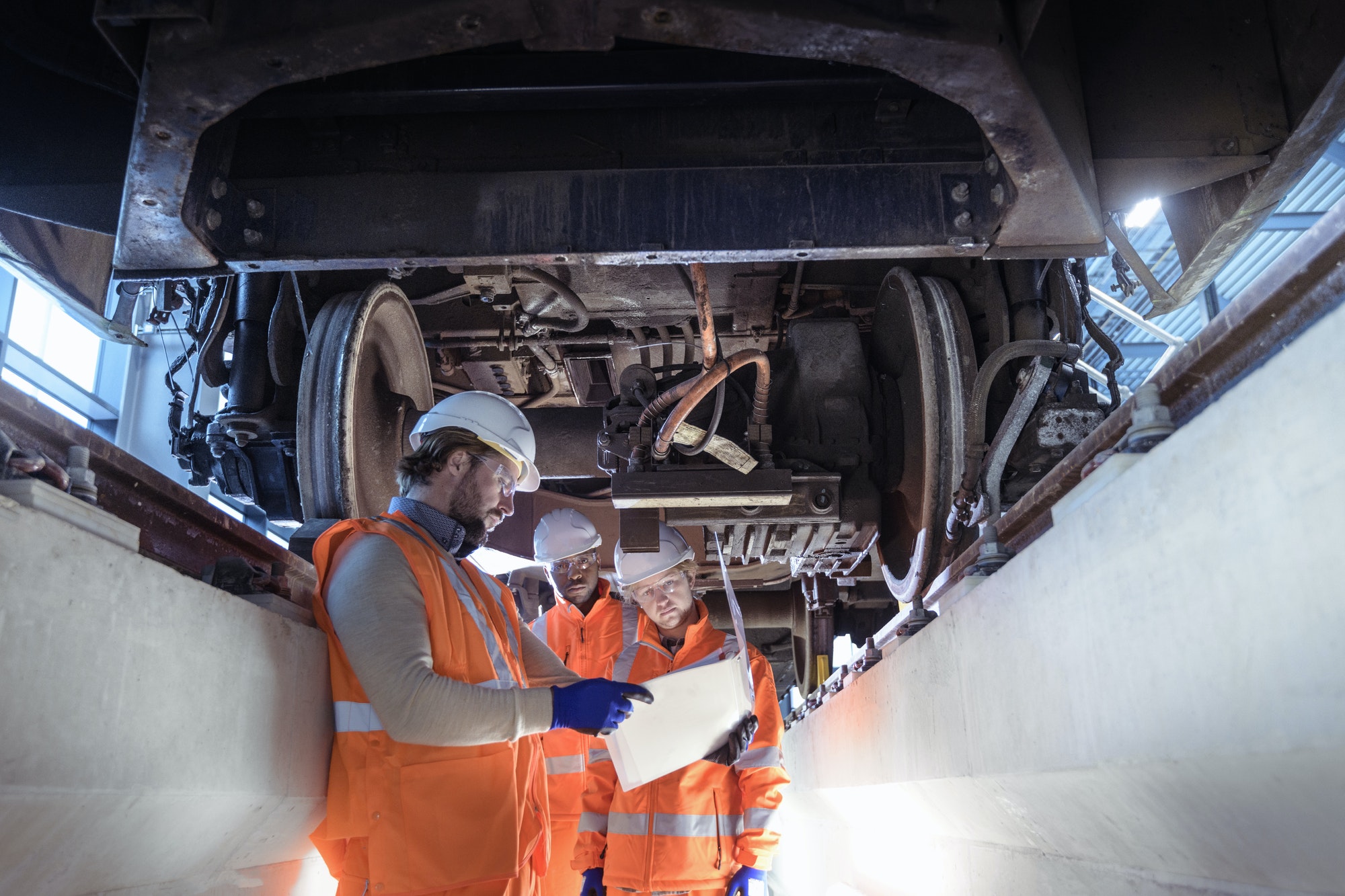 Instructeur et apprentis en formation dans une installation de génie ferroviaire