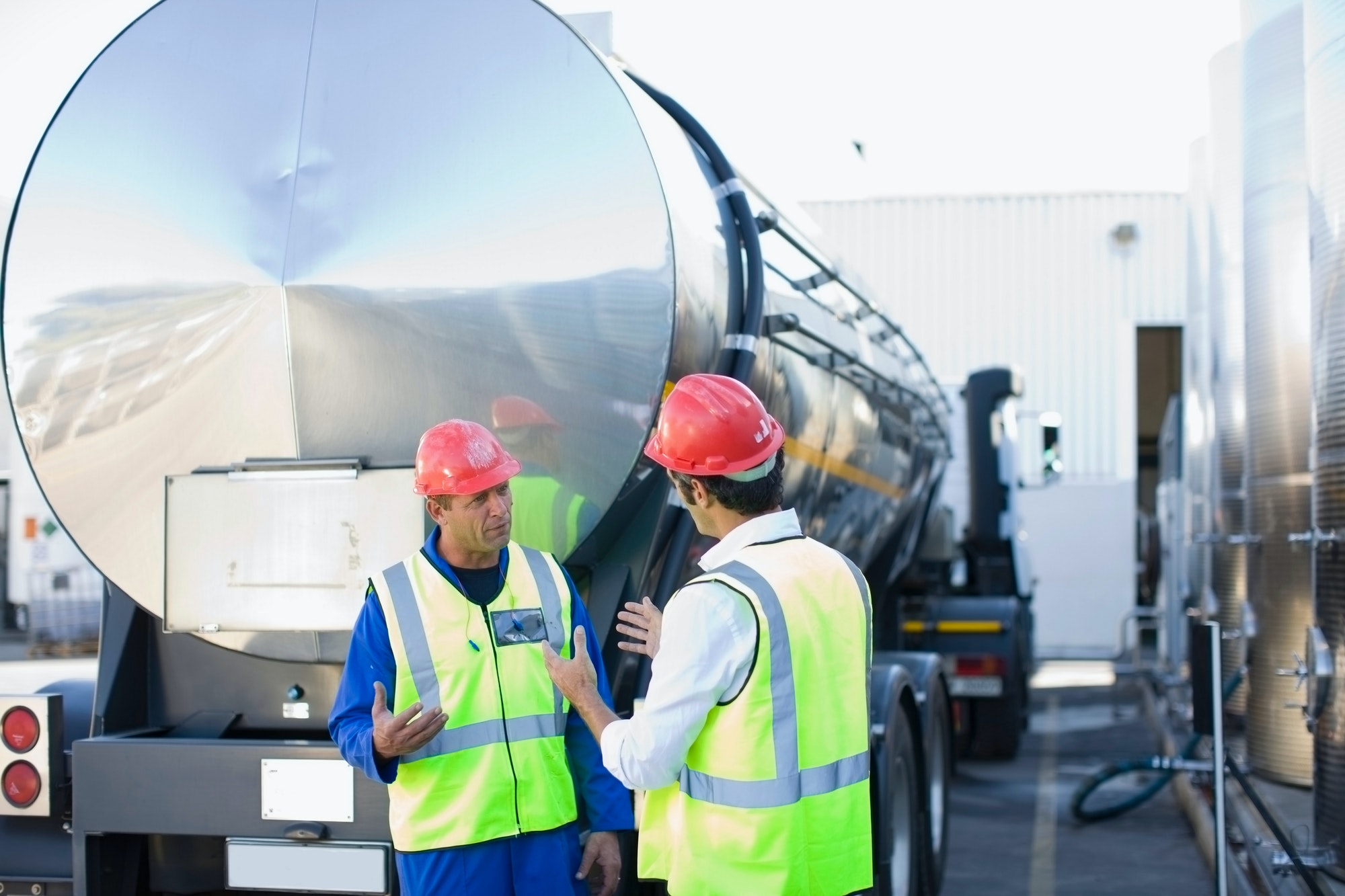 Ouvriers parlant par un camion-citerne